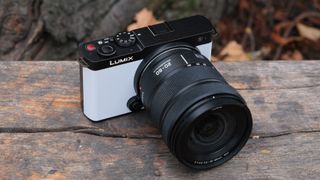 Panasonic Lumix S9 camera in white outside on a wooden bench in front of a tree