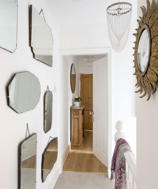 hallway area with patterned wall mirrors and white walls