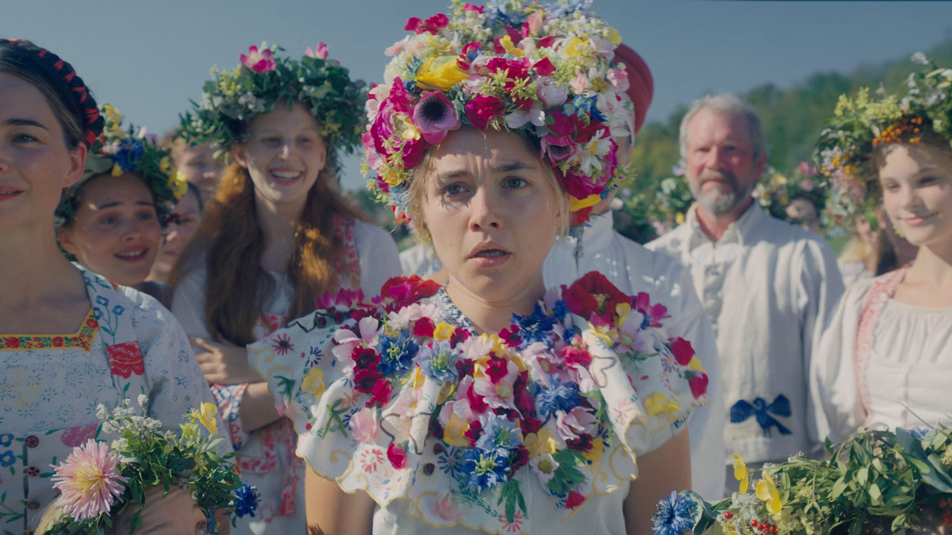Dani looks shocked as she stands next to some other women in A24 folk horror movie Midsommar