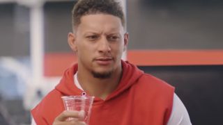 Patrick Mahomes drinks a glass of water and looks confused during a State Farm commercial.