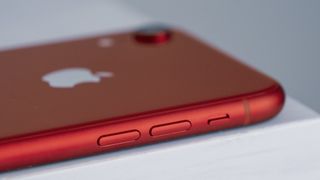 An iPhone XR in red, viewed from the side