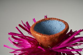 detail of colourful vase with pink raffia ruff