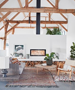 View of an interior fireplace white wall with log store underneath the shelf