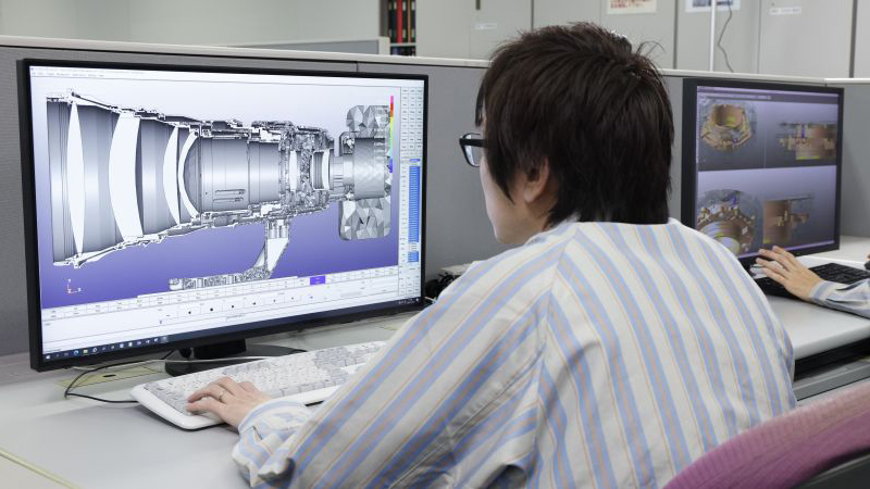 A Canon lens designer working on a computer with a diagram of an optical formula