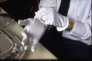 Person putting on silver cleaning gloves