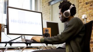 Man wearing headphones at work in his home studio