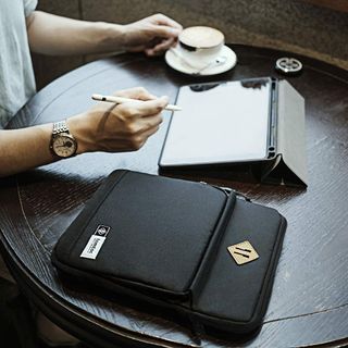 Tomtoc Tablet shoulder bag on table with person working on ipad