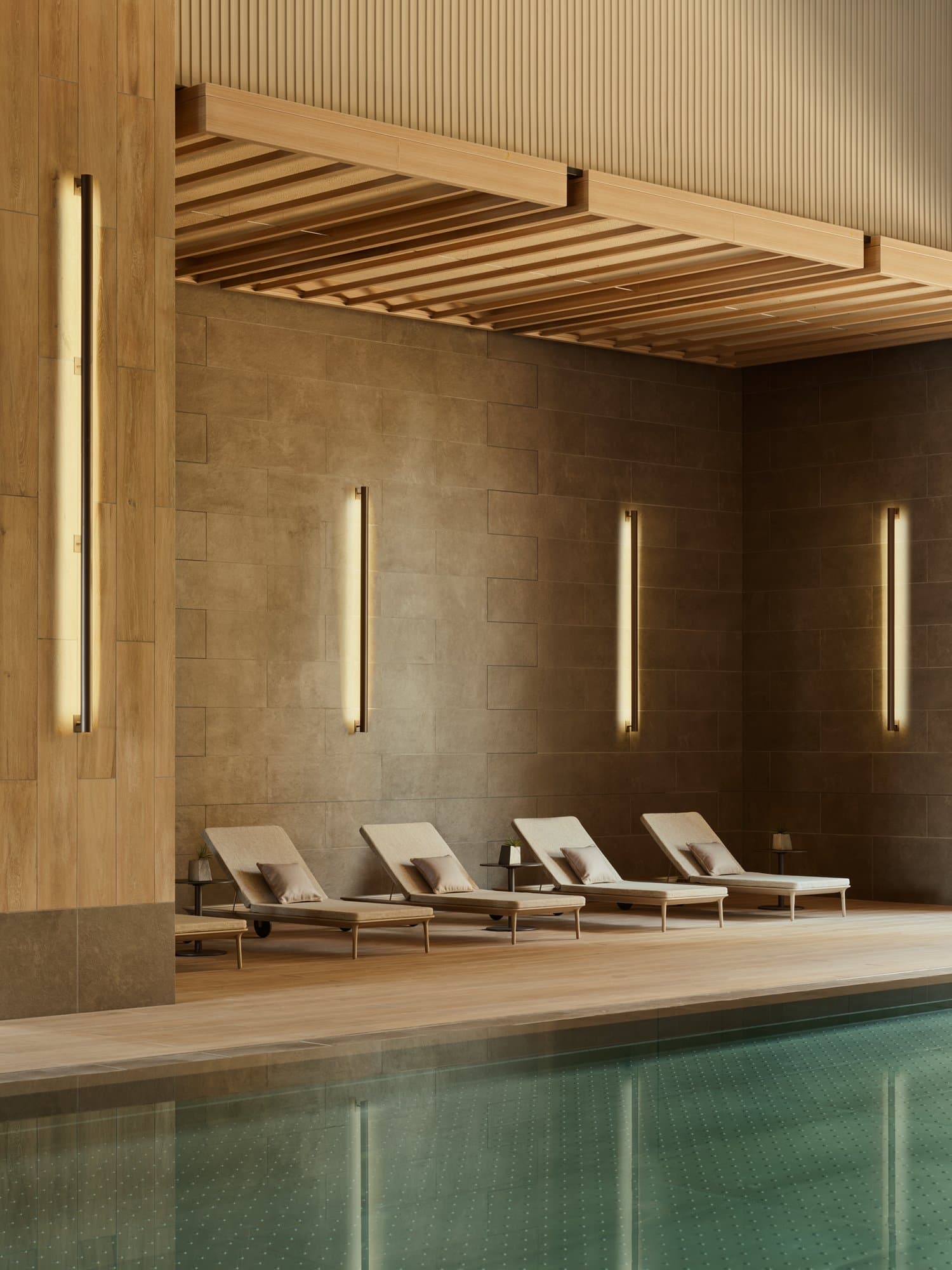 A golden-hued hotel spa pool features sophisticated, elegant brick walls with back-lit linear sconces, minimalist beige deck chairs, textured ceilings and higher walls, and a sea foam green pool bed.