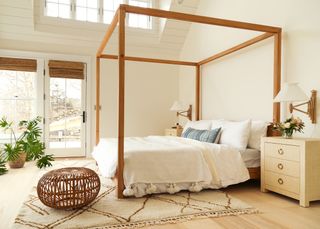 White bedroom with wooden four poster bed