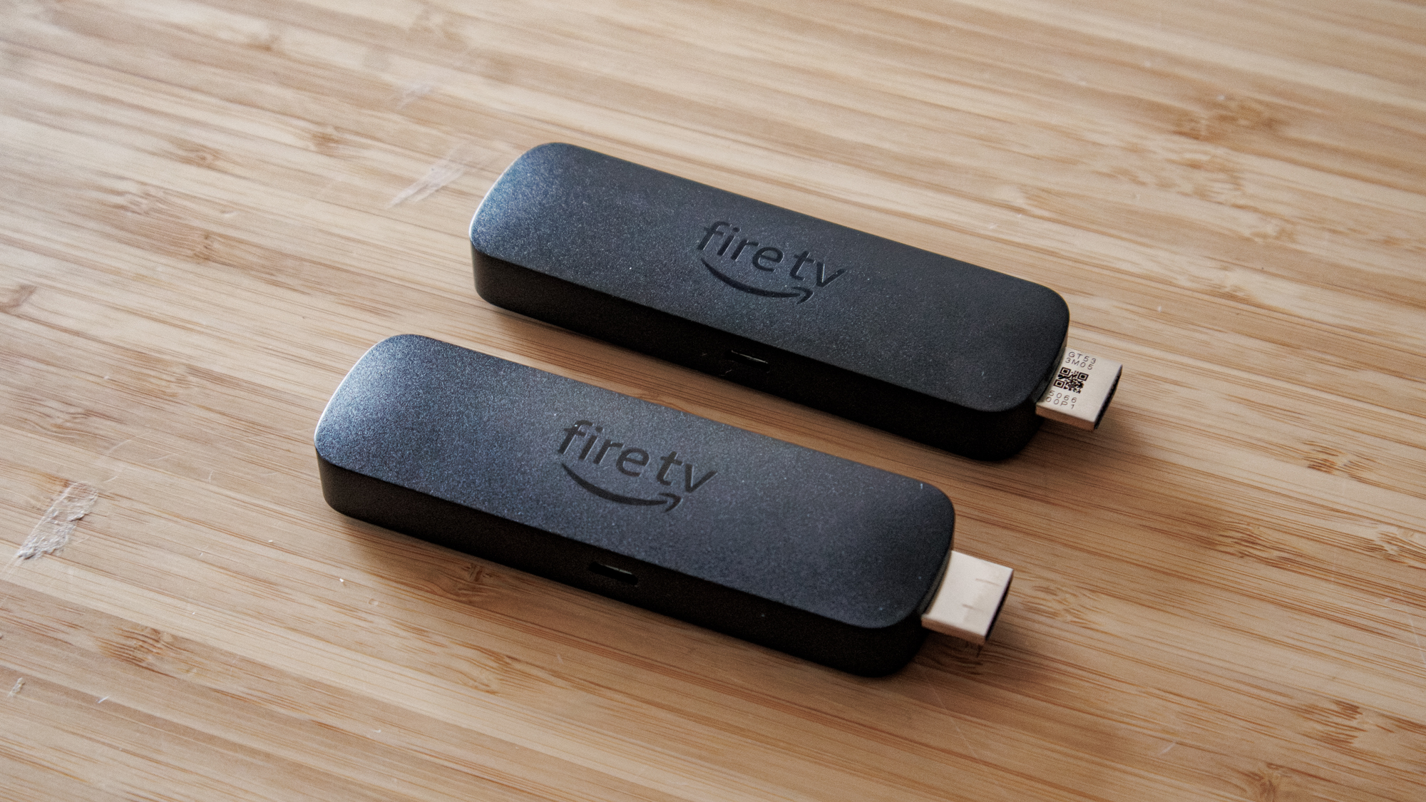 Amazon Fire TV Stick 4K Select and 4K Plus side by side on a table