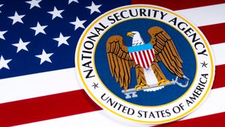 The logo of the National Security Agency in front of the US flag