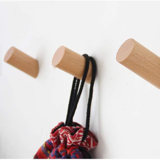 A set of wooden wall hooks attached to a wall. 