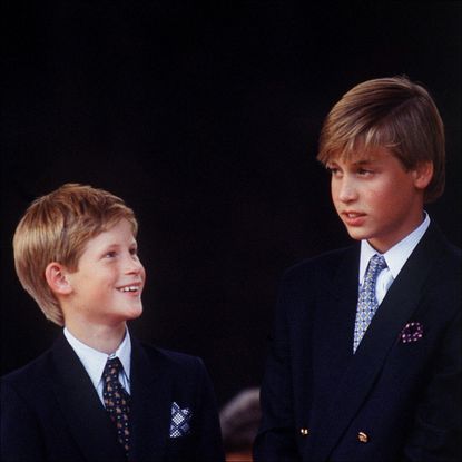 Princess Diana wearing a big white and blue hat and Tomasz Starzewski suit as she stands with her sons Prince Harry and Prince William at a parade to Commemorate the 50th Anniversary of VJ Day