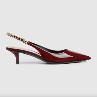 a pair of red gucci slingback heels in front of a plain backdrop