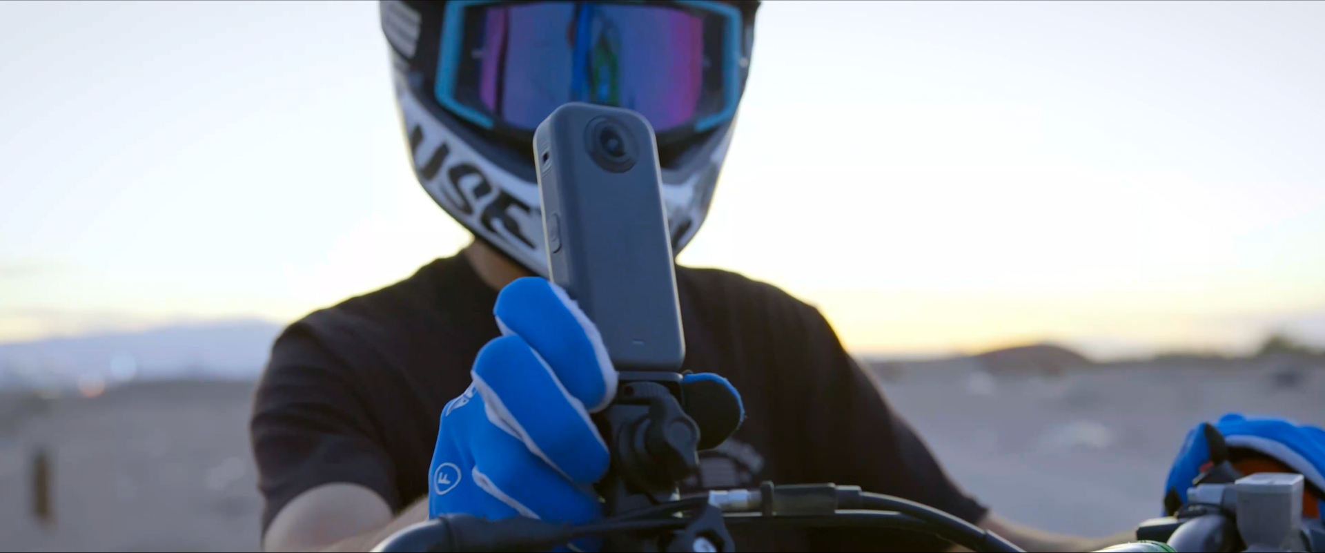 Akaso 360 camera mounted to an MTB, with helmeted rider adjusting it