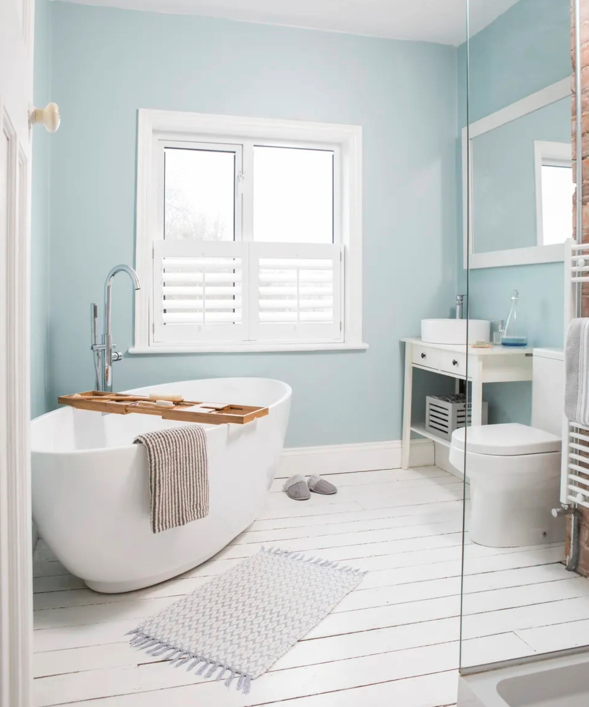 Bathroom with pastel blue walls and freestanding bath