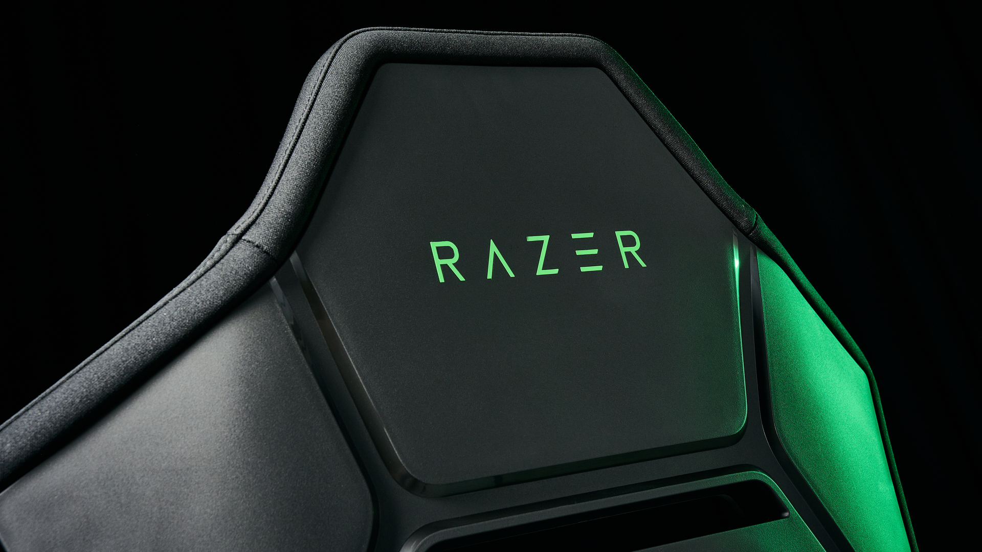 The Razer Soma Chroma chair back, illuminated with a green glow