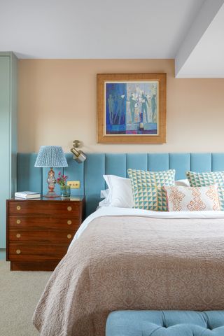 Blue and orange bedroom with velvet headboard