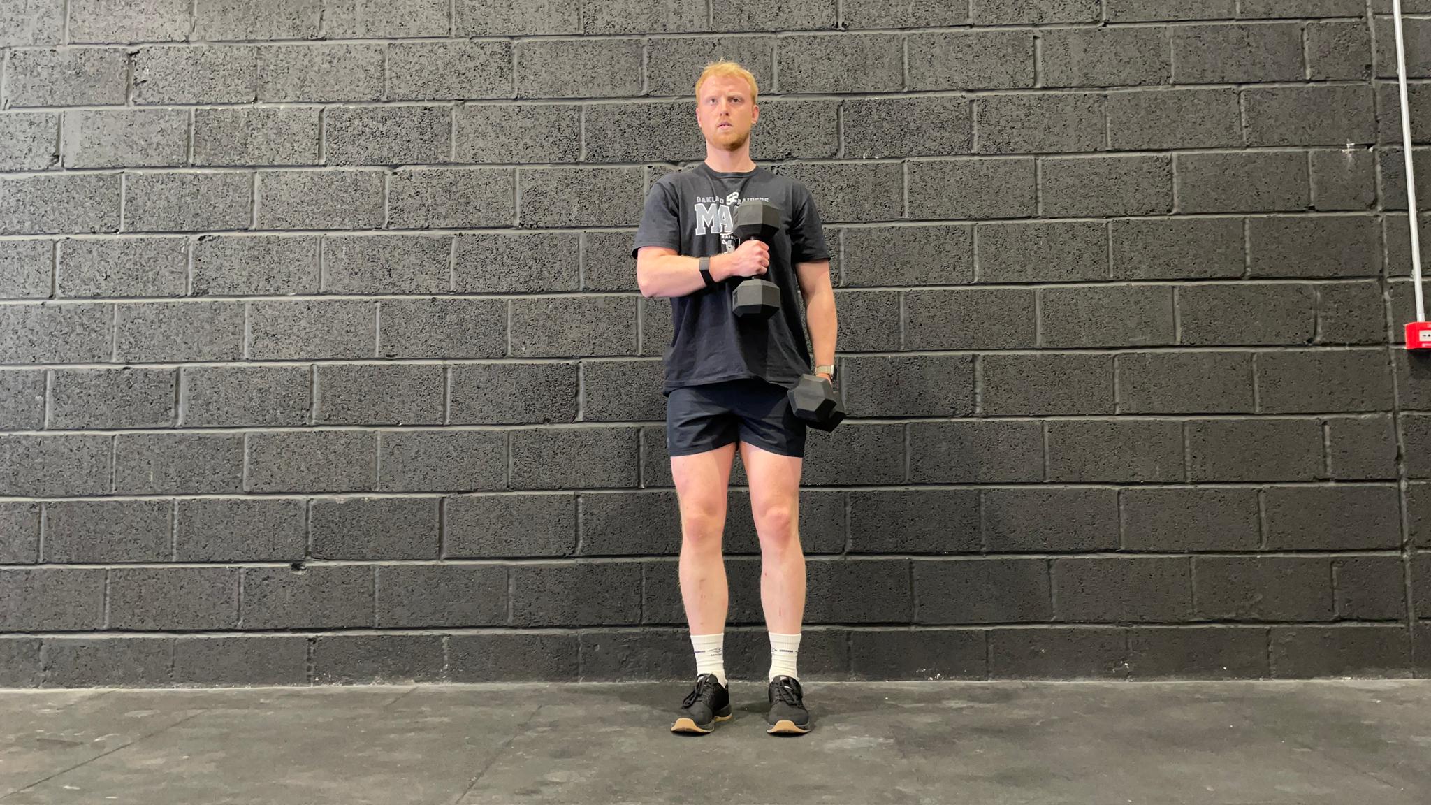 TechRadar fitness writer Harry Bullmore demonstrating a cross-body hammer curl