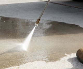 pressure washer being used on driveway