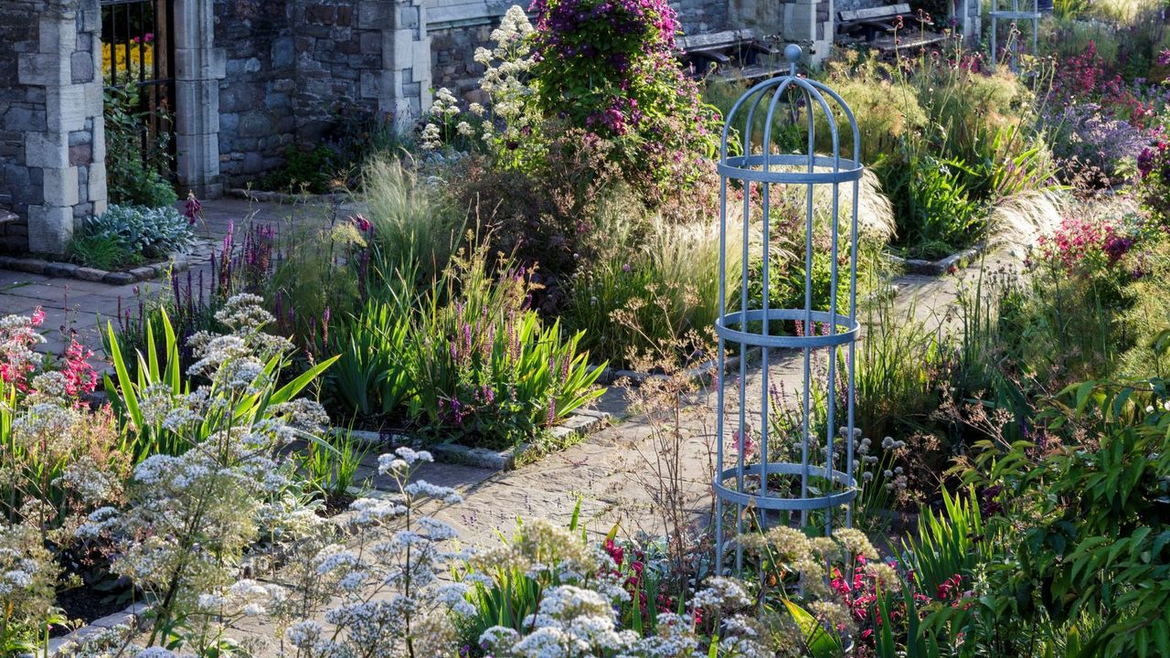 A bright and colorful garden with a paved pathway