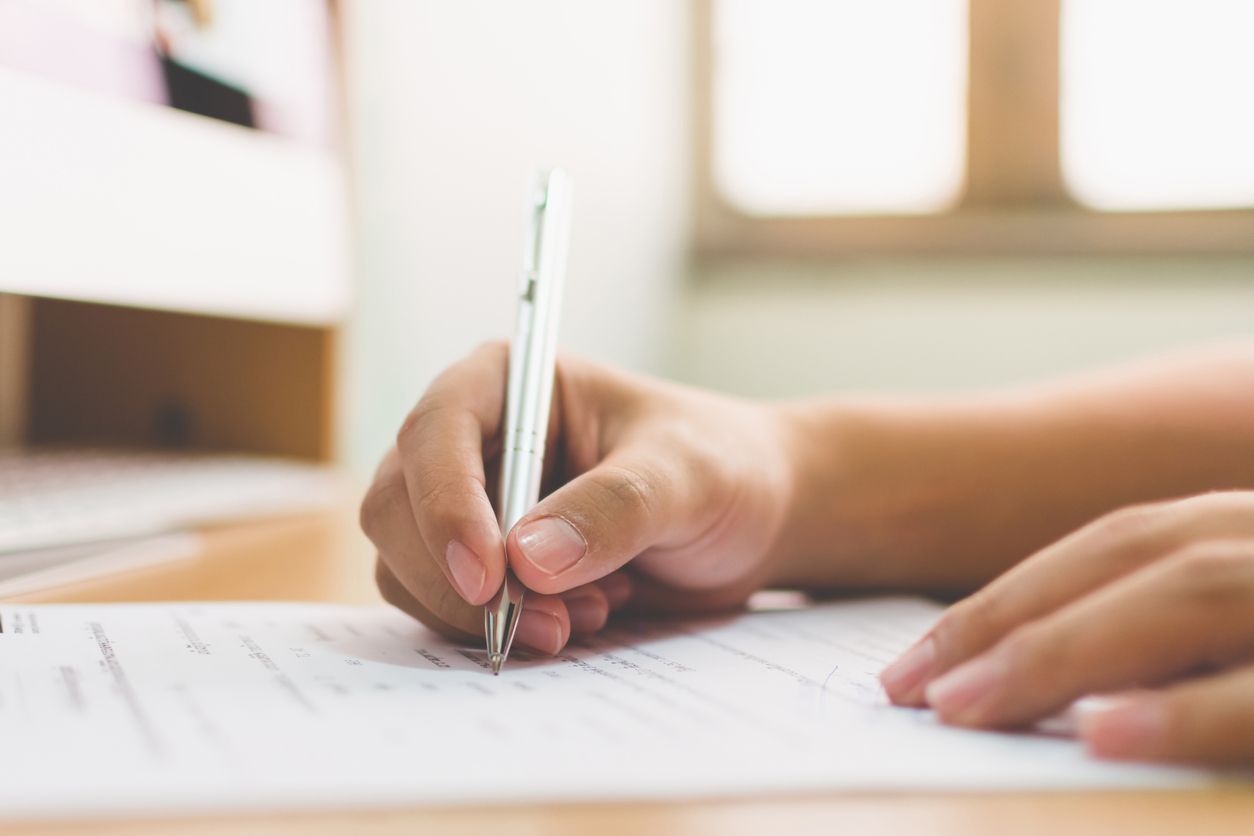 A person uses a pen to write.