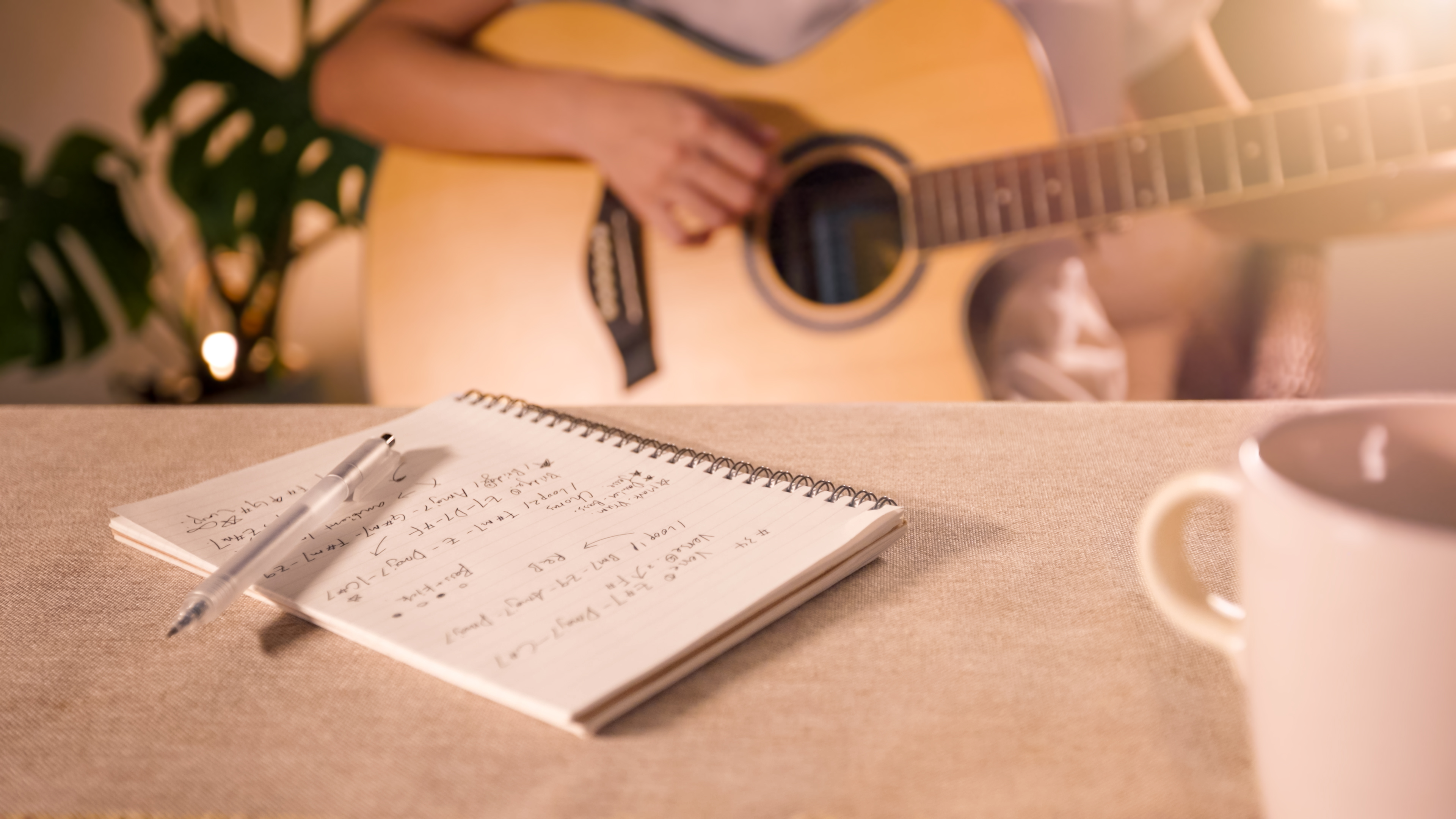 A man plays the guitar while sitting down