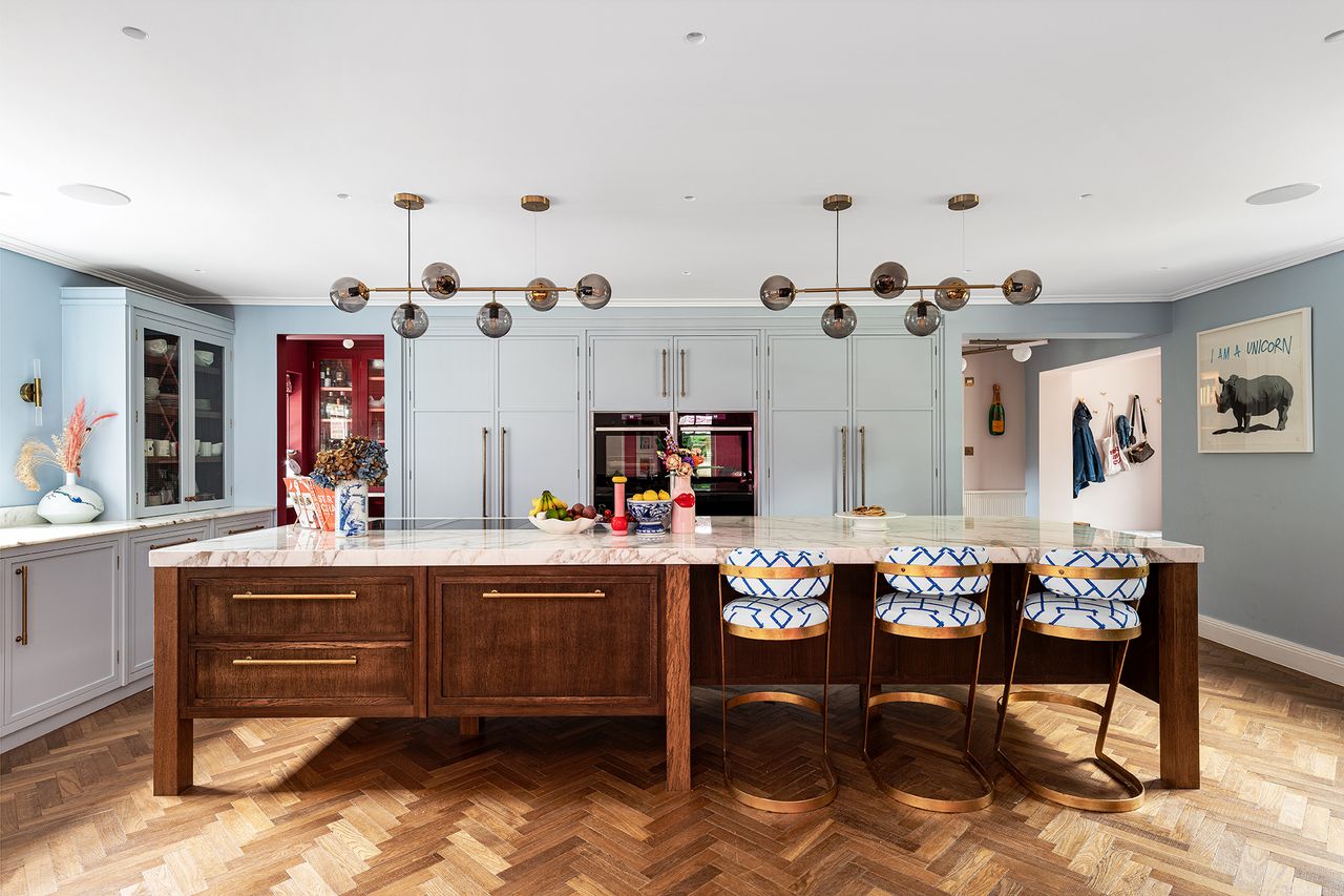 Kitchen island with chairs, lighting and marble worktop