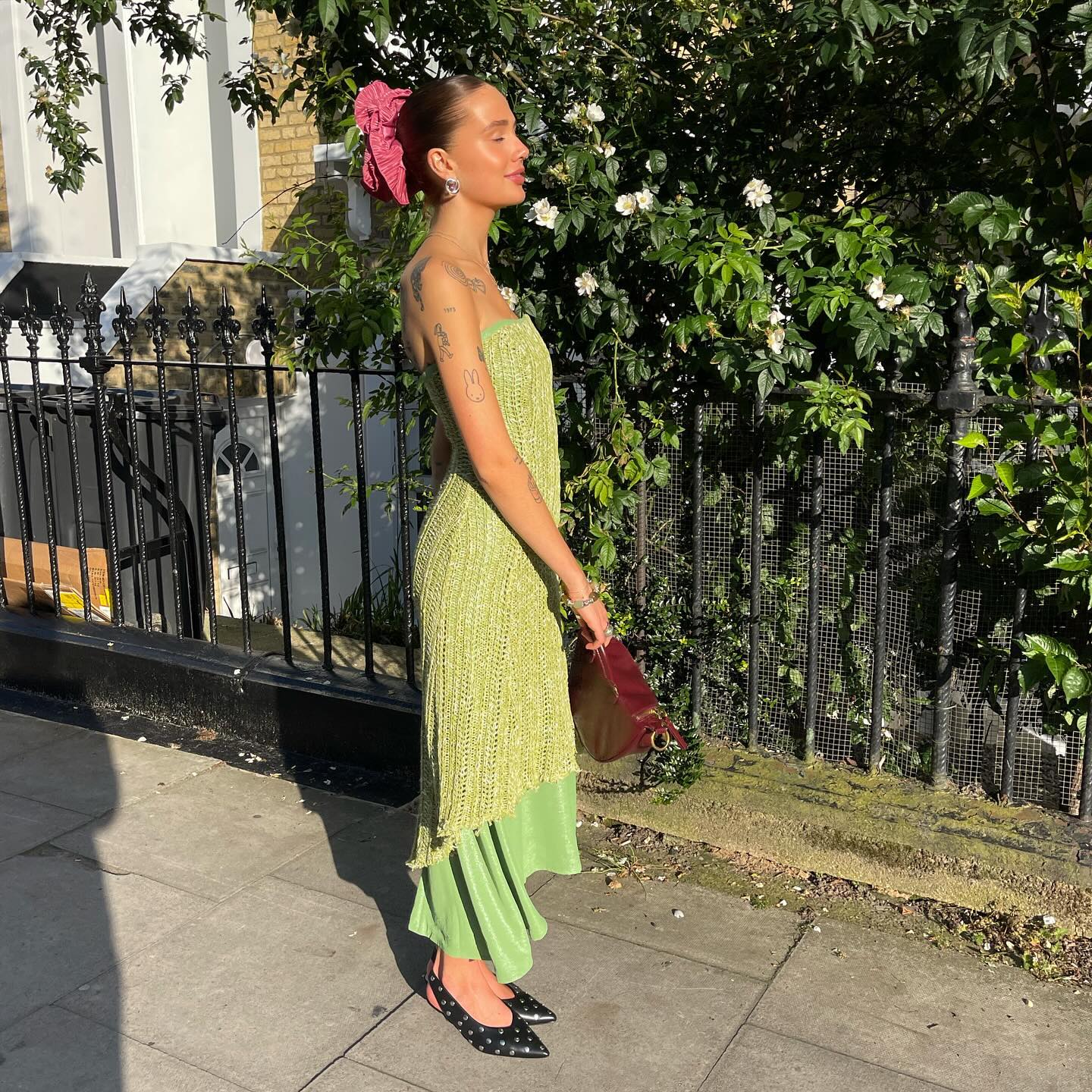 @evie_mills wears a green sequin bandeau dress with an asymmetric hem