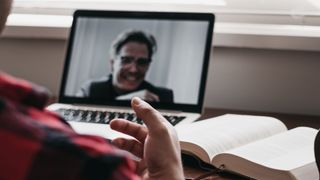 A person having a video call with another person at a desk