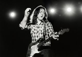 Rory Gallagher photographed in a studio for his 'Top Priority' album cover on 11th June 1979. He plays a Fender Stratocaster guitar.