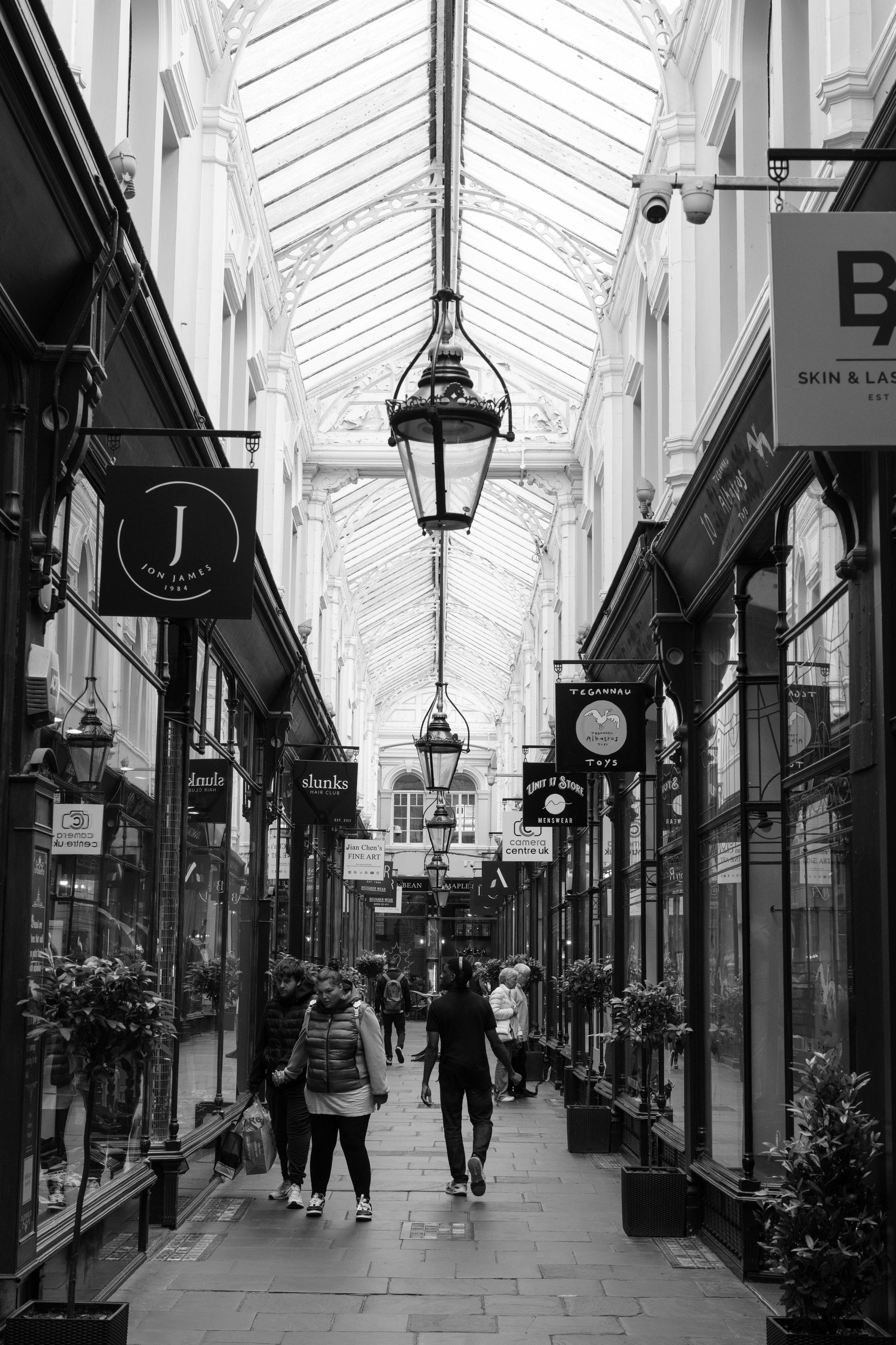 A black and white photo of a shopping arcade.