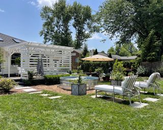 backyard with white pergola, seating and stock tank pool