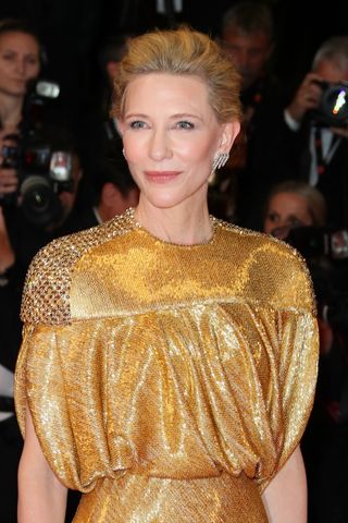 Cate Blanchett is pictured with golden hair in an updo while attending the "Rumours" Red Carpet at the 77th annual Cannes Film Festival at Palais des Festivals on May 18, 2024 in Cannes, France.