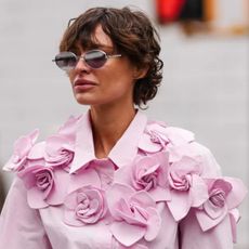 woman with a short crop wearing beautiful floral pink shirt