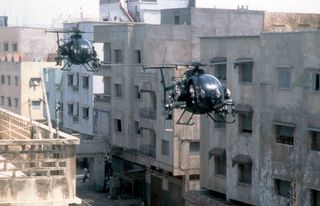 Two helicopters joined together as they approach combat in a scene from the film Black Hawk Down (2001).