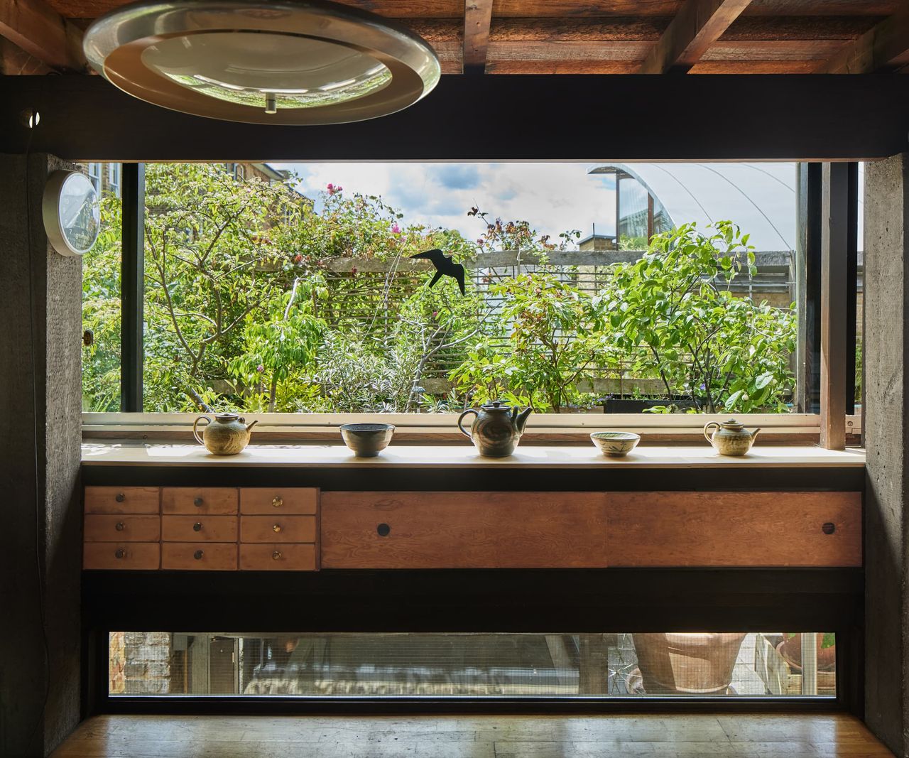 A picture window with a wooden shelf in front