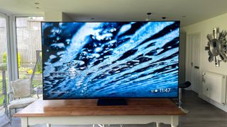 TCL 85C805K 4K TV pictured from front on table showing water effects on screen
