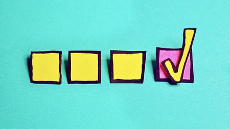 A colorful checklist with three yellow squares and a pink square outlined in black and a yellow checkmark in the pink square.