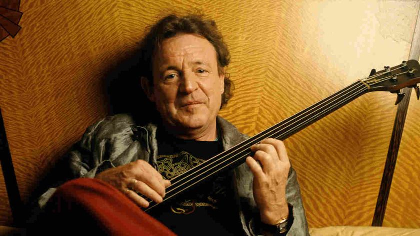 Jack Bruce posing for a photograph with a bass guitar in 2001