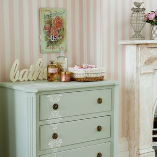 green chest drawers with pink stripe wallpaper