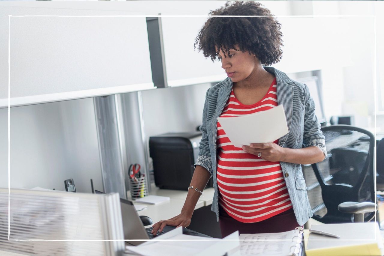 Pregnant woman in an office looking at maternity pay forms