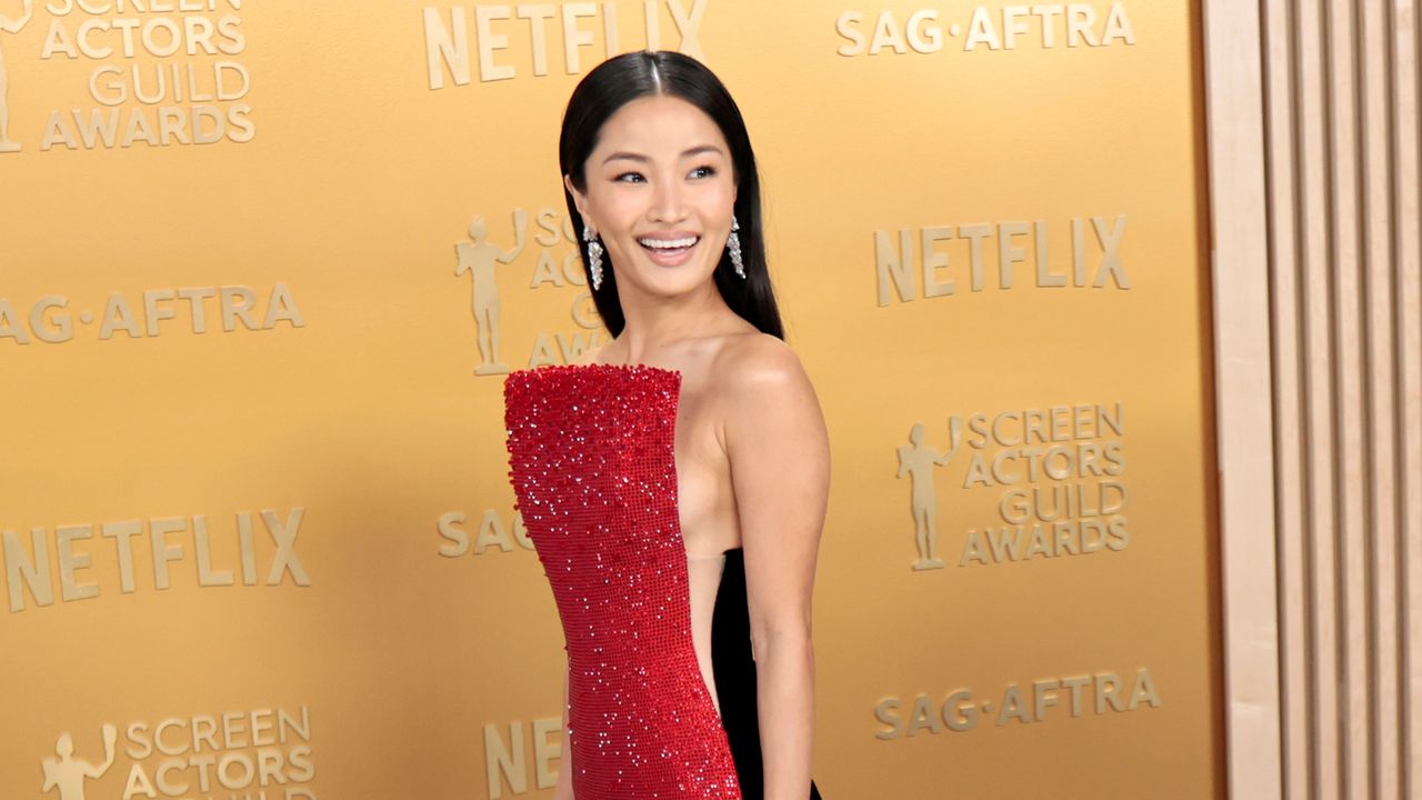 Anna Sawai attends the 2025 SAG Awards wearing a red dress with side cut-outs