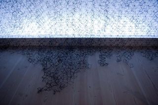 Upclose view of black mesh hanging off a wall ontop laminated floor