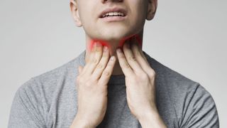 What Are Tonsil Stones? Image shows man feeling painful throat