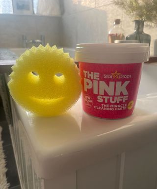 A yellow Scrub Daddy sponge and a tub of The Pink Stuff paste