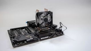 An Amazon CPU cooler attached to a motherboard against a gray background