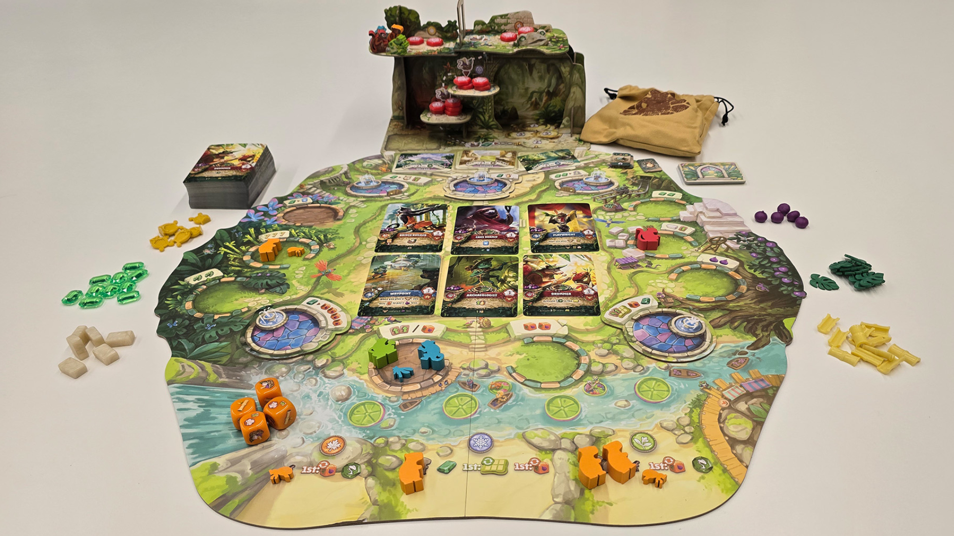 Emerland board, cards, tokens, and icons set up mid-game against a plain background