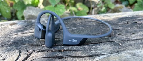 Shokz OpenRun Pro 2 headphones on a log