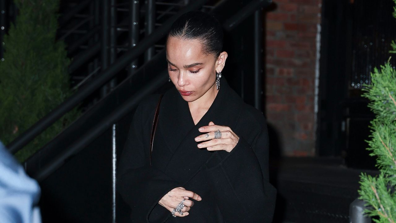 Zoë Kravitz walking in New York City wearing a black coat and several diamond rings